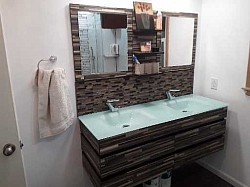 Floating vanity with solid glass top