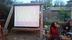 Pull down movie screen mounted a top the bench swing