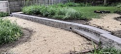 Double stacked 8x18x12 square edged block with a 3 1/2x16x12 flush cap. Two sets of integrated stairs. Four inch drain tile fully backfilled, seeded, fertilized and restored to better then when we arrived.